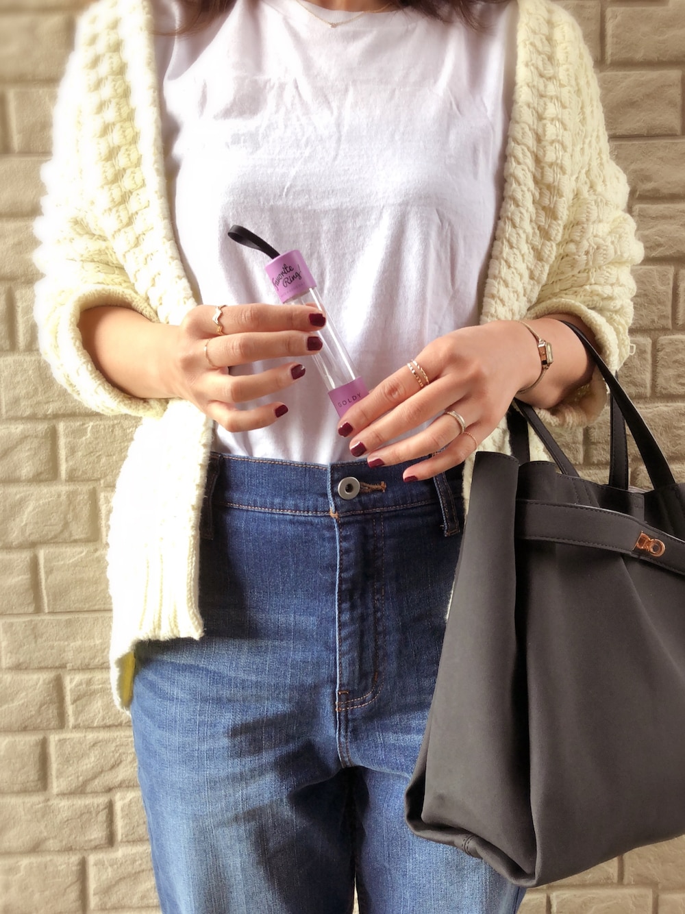 ホワイト系のTシャツ/カットソー、ホワイト系のニット/セーター、ブルー系のデニムパンツを着用したレディースの秋コーディネートの1枚目の写真