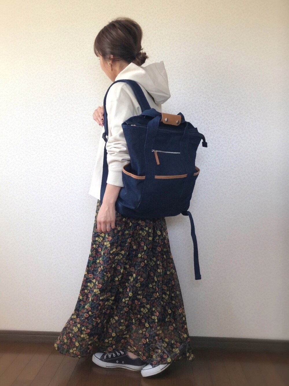 ブルー系のバックパック/リュック、ベージュ系のパーカー、ブラック系のスカートを着用したレディースの秋コーディネートの1枚目の写真