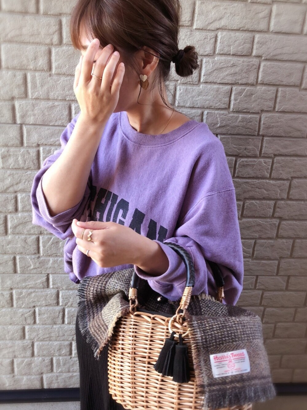 パープル系のスウェット、ブラック系のかごバッグ、ブラック系のスカートを着用したレディースの秋コーディネートの1枚目の写真