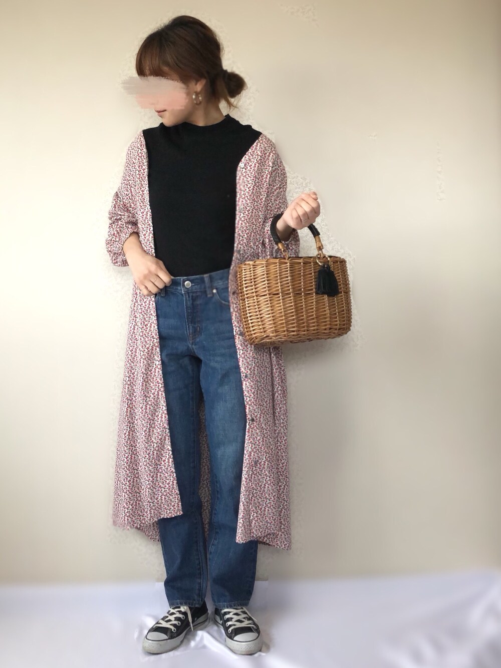 ブルー系のデニムパンツ、ブラック系のかごバッグ、ブラック系のスニーカーを着用したレディースの春コーディネートの1枚目の写真