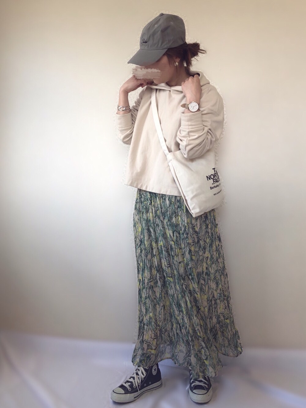 ベージュ系のスカート、ベージュ系のパーカー、ブラック系のショルダーバッグを着用したレディースの春コーディネートの1枚目の写真