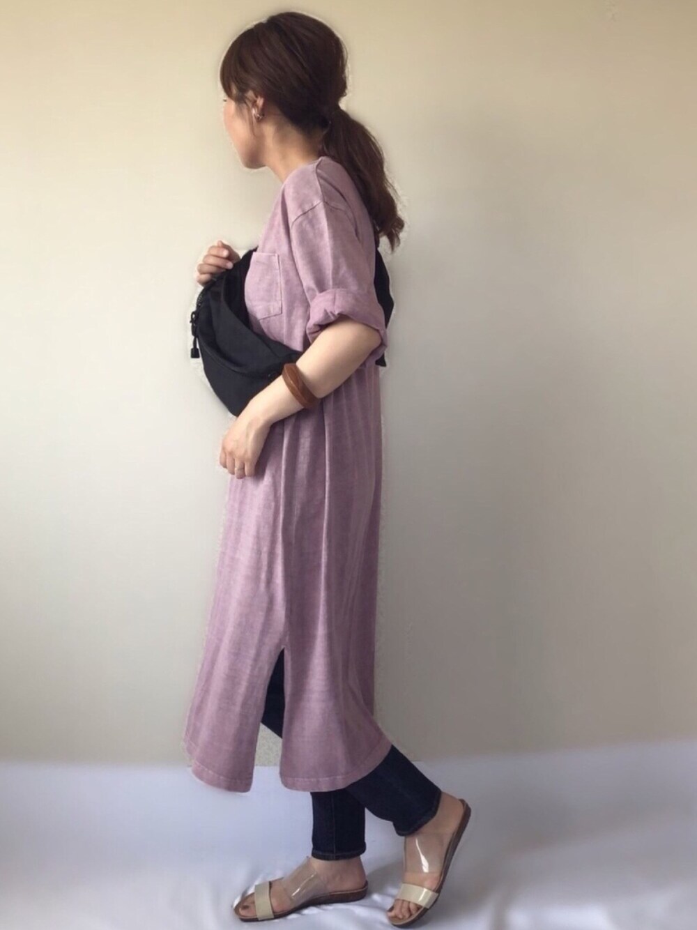 パープル系のワンピース、ブルー系のデニムパンツ、ブラック系のボディバッグ/ウエストポーチを着用したレディースの夏コーディネートの1枚目の写真