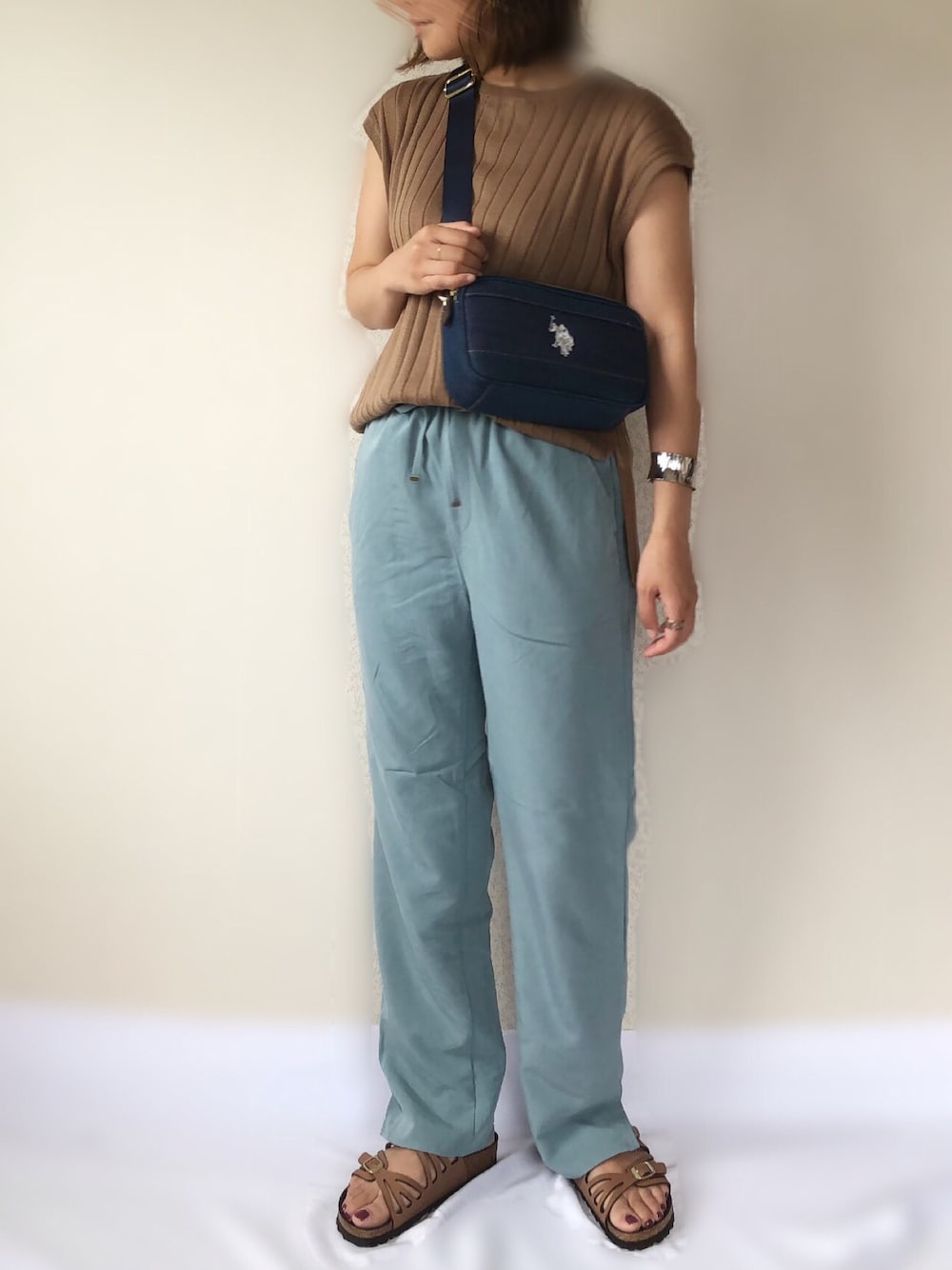 グリーン系のその他パンツ、ベージュ系のニット/セーター、ブルー系のショルダーバッグを着用したレディースの夏コーディネートの1枚目の写真