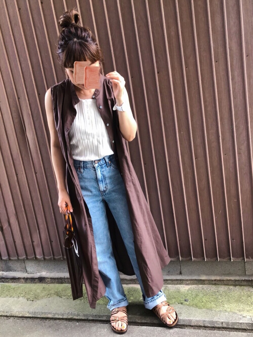 ブルー系のデニムパンツ、ブラウン系のワンピース、ホワイト系のタンクトップを着用したレディースの夏コーディネートの1枚目の写真