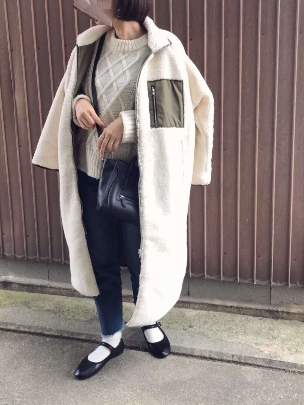 ブラック系のバレエシューズ、ホワイト系のその他アウター、ホワイト系のニット/セーターを着用したレディースの冬コーディネートの1枚目の写真