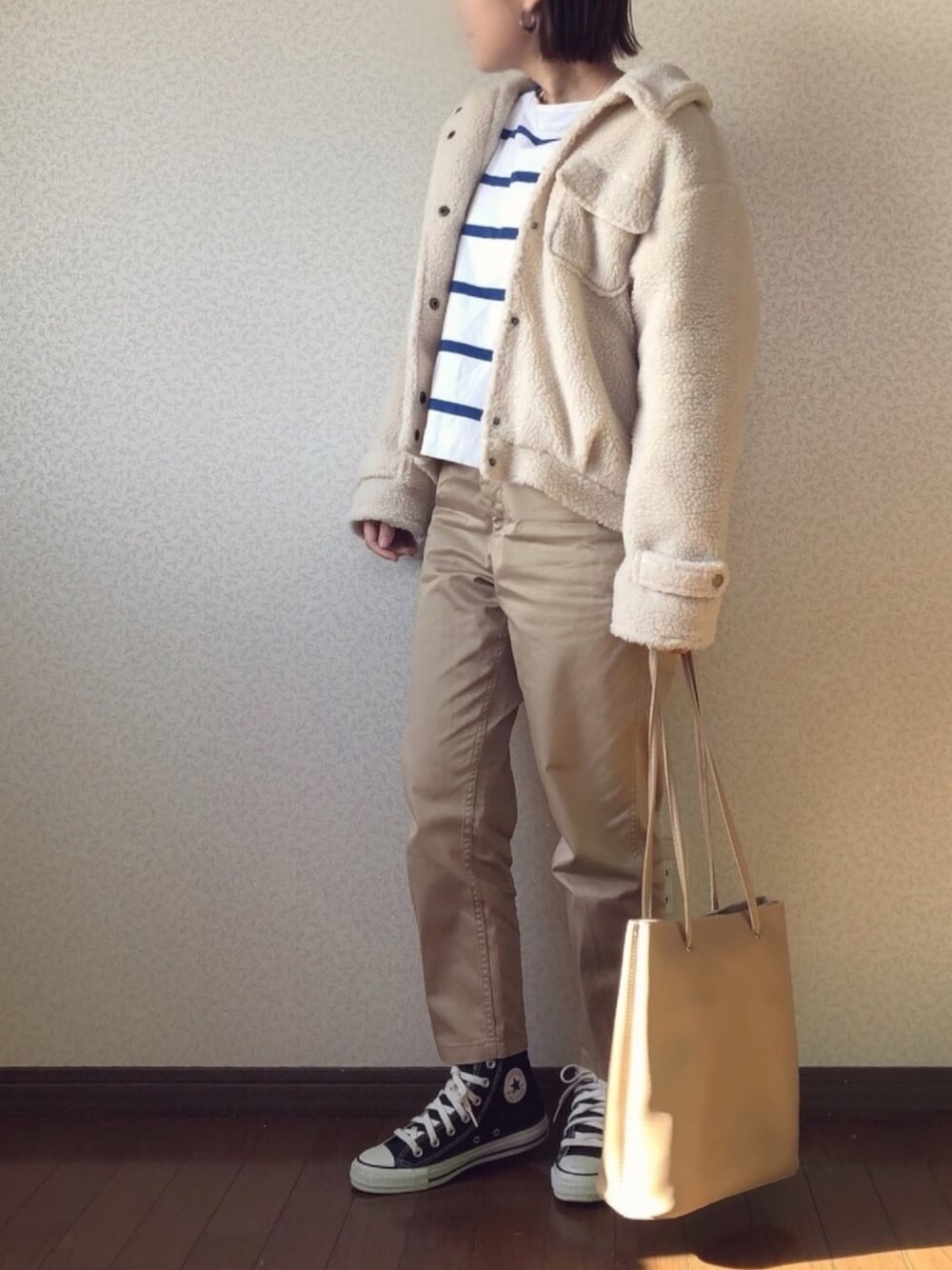 ホワイト系のその他アウター、ブルー系のTシャツ/カットソー、ベージュ系のチノパンツを着用したレディースの冬コーディネートの1枚目の写真