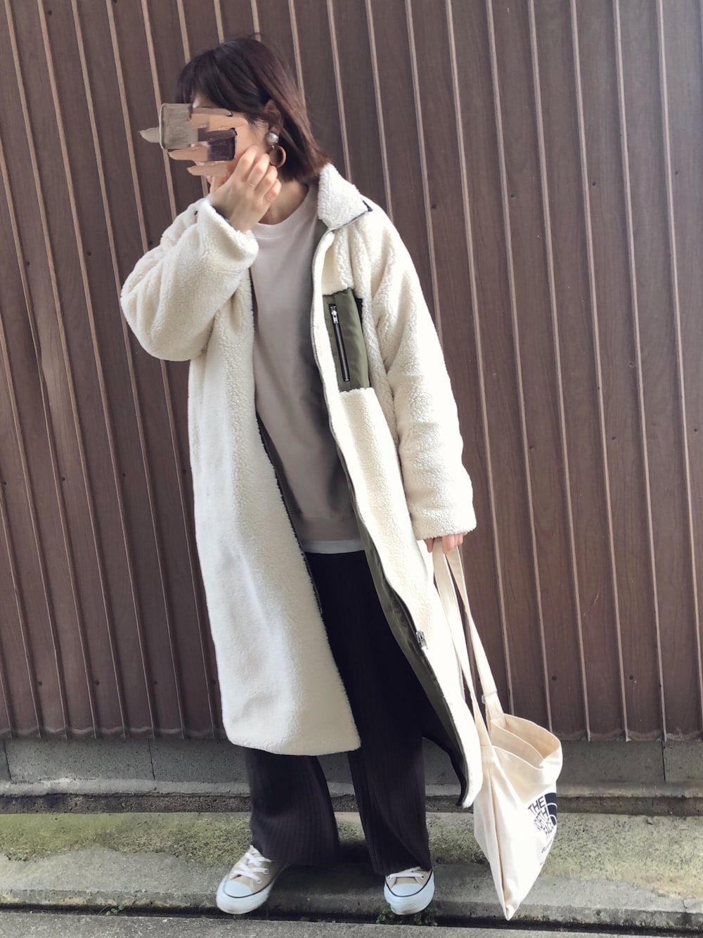 ブラウン系のスウェットパンツ、ベージュ系のスウェット、ホワイト系のその他アウターを着用したレディースの冬コーディネートの1枚目の写真