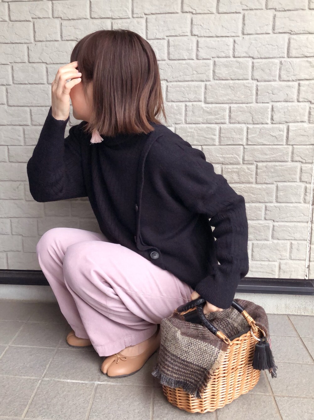 ブラック系のニット/セーター、ピンク系のその他パンツ、ブラック系のかごバッグを着用したレディースの冬コーディネートの1枚目の写真