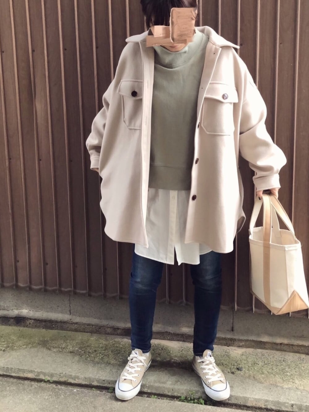 ベージュ系のカバーオール、グリーン系のTシャツ/カットソー、ホワイト系のシャツ/ブラウスを着用したレディースの冬コーディネートの1枚目の写真