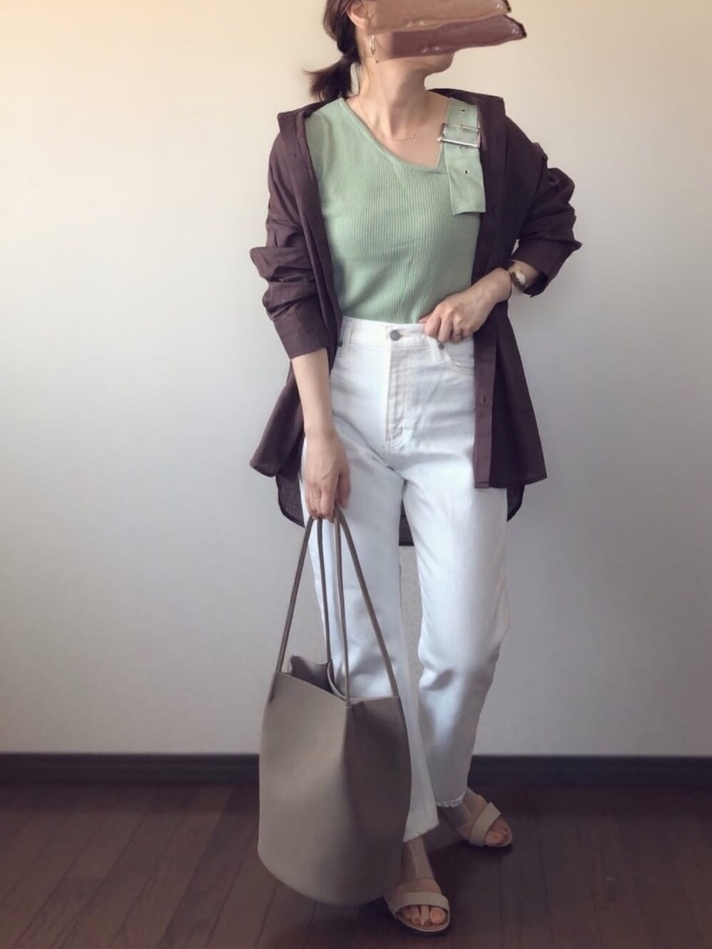ホワイト系のデニムパンツ、グリーン系のニット/セーター、ブラウン系のシャツ/ブラウスを着用したレディースの春コーディネートの1枚目の写真