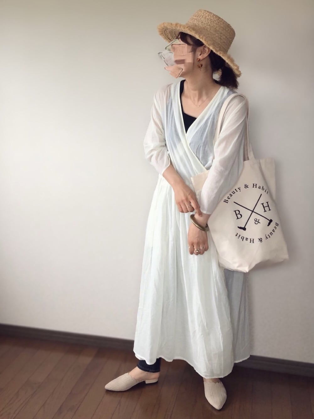 ホワイト系のワンピース、ブラック系のタンクトップ、ブルー系のデニムパンツを着用したレディースの夏コーディネートの1枚目の写真