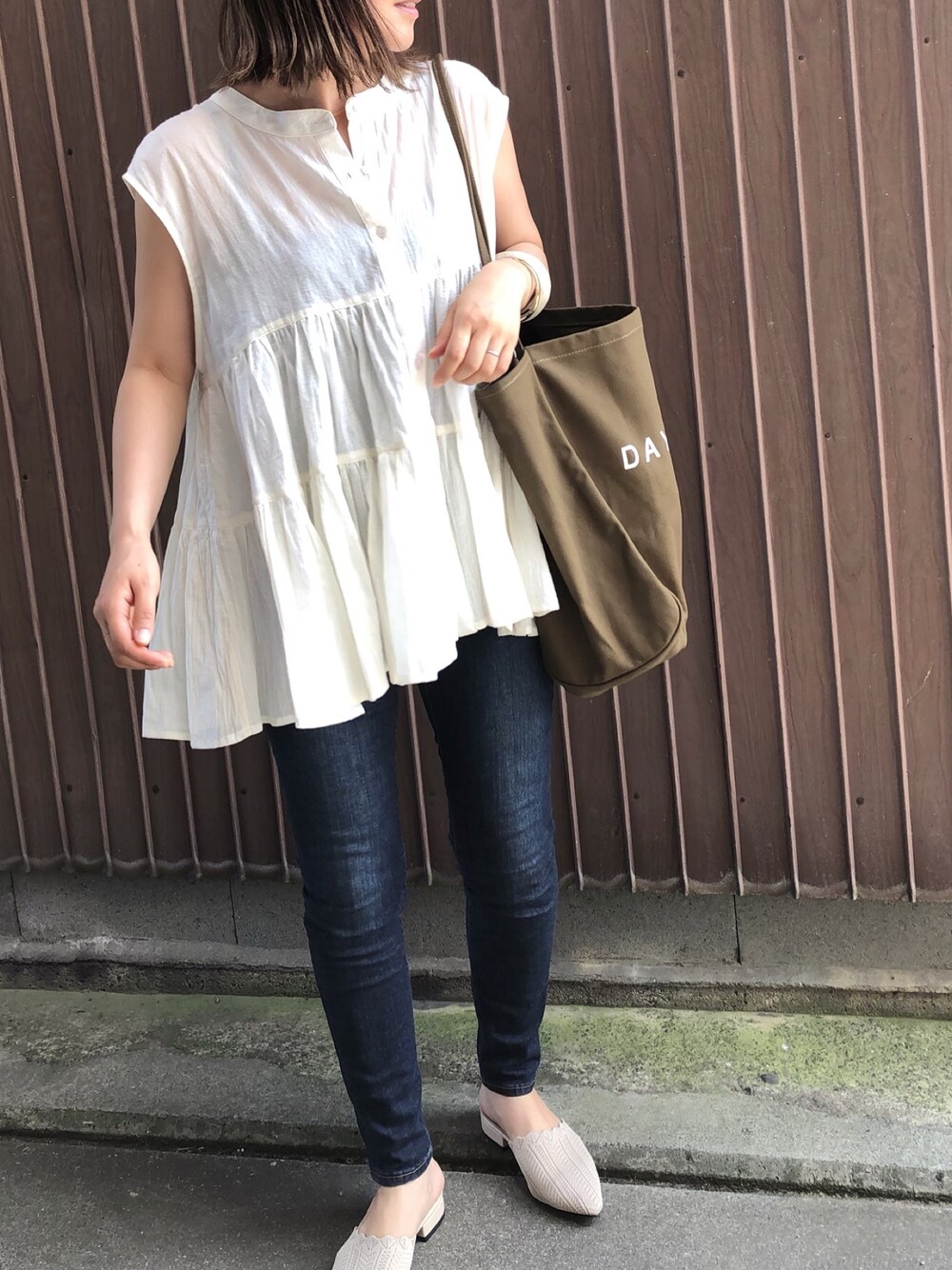 ブラウン系のトートバッグ、ベージュ系のシャツ/ブラウス、ベージュ系のサンダルを着用したレディースの夏コーディネートの1枚目の写真