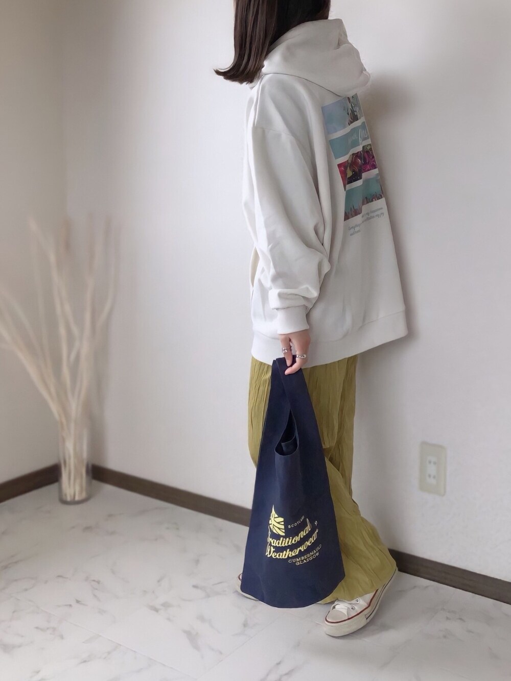 ホワイト系のパーカー、イエロー系のその他パンツ、ブルー系のトートバッグを着用したレディースの冬コーディネートの1枚目の写真