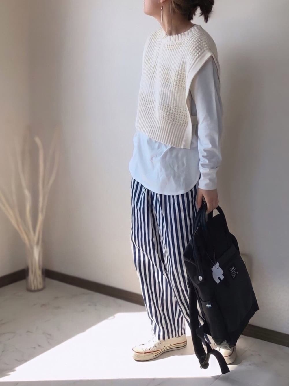 ホワイト系のTシャツ/カットソー、ブラック系のバックパック/リュック、ホワイト系のスニーカーを着用したレディースの冬コーディネートの1枚目の写真