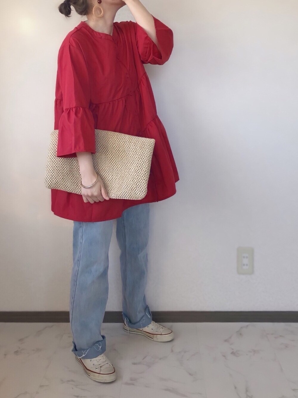 レッド系のシャツ/ブラウス、ブルー系のデニムパンツ、ベージュ系のショルダーバッグを着用したレディースの春コーディネートの1枚目の写真