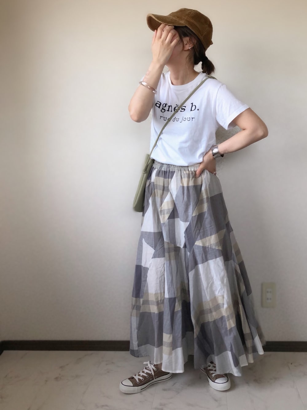 ホワイト系のTシャツ/カットソー、ベージュ系のスカート、グリーン系のショルダーバッグを着用したレディースの春コーディネートの1枚目の写真