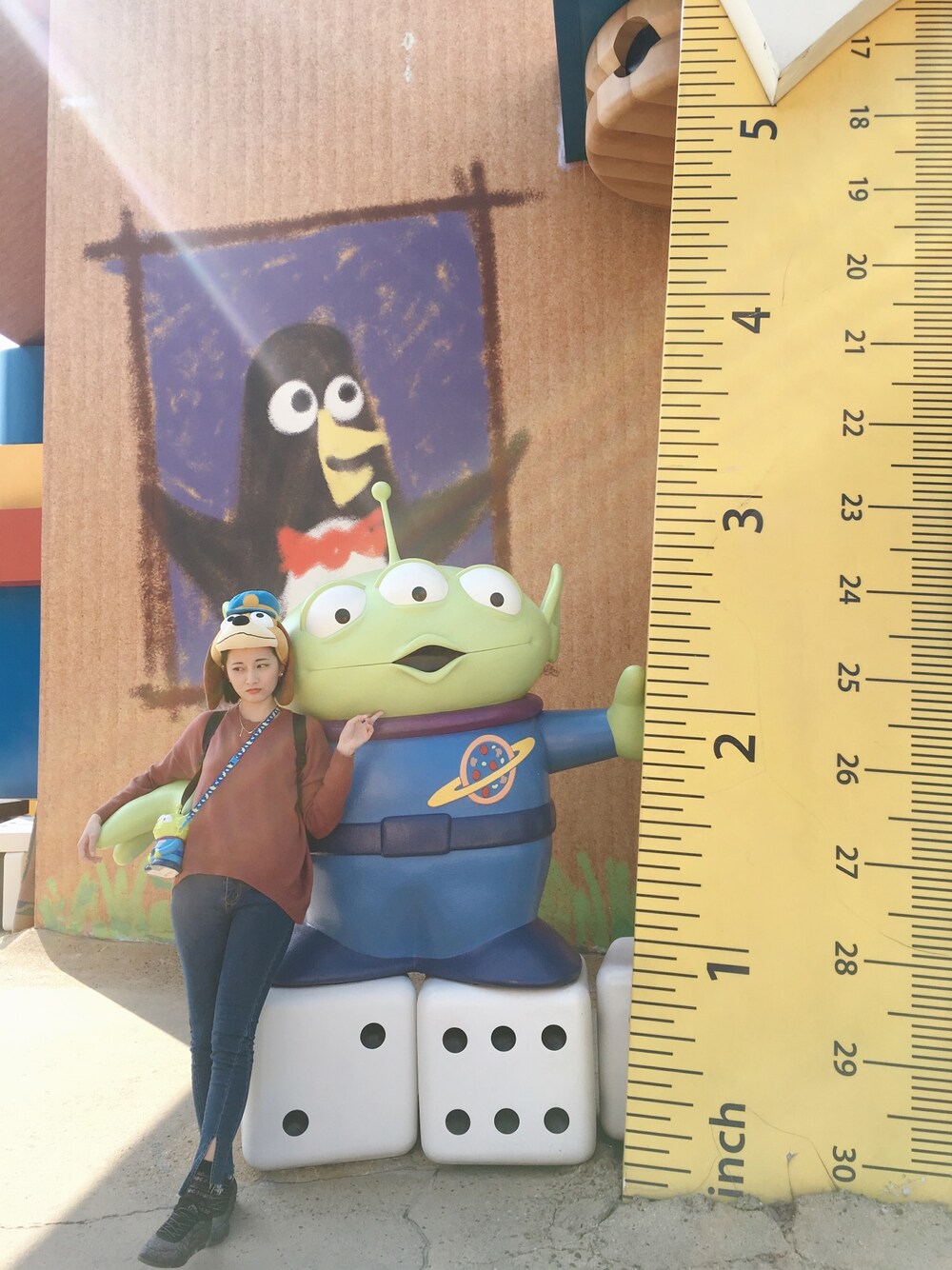 グリーン系のおもちゃ、ブラウン系の帽子を着用したレディースの冬コーディネートの1枚目の写真