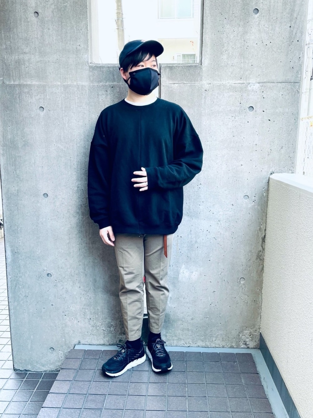 グレー系のチノパンツ、ブラック系のスニーカー、ブラック系のスウェットを着用したメンズの冬コーディネートの1枚目の写真
