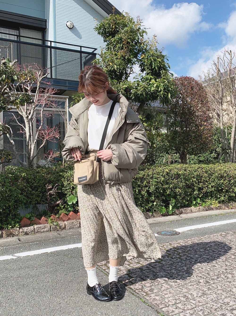 グリーン系のダウンジャケット/コート、ホワイト系のシャツ/ブラウスを着用したレディースの春コーディネートの1枚目の写真