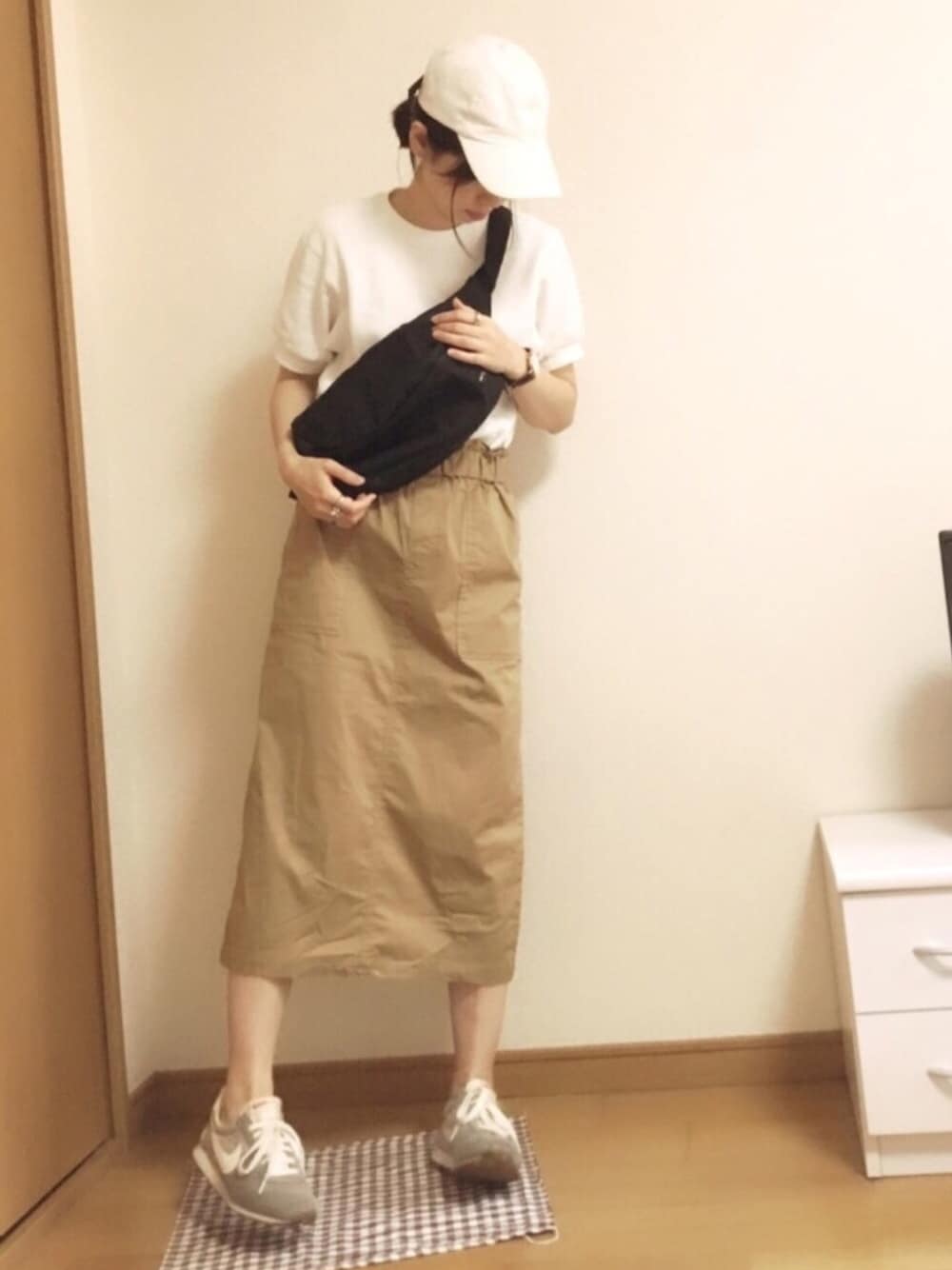 ベージュ系のスカート、グレー系のスニーカー、ブラック系のボディバッグ/ウエストポーチを着用したレディースの夏コーディネートの1枚目の写真