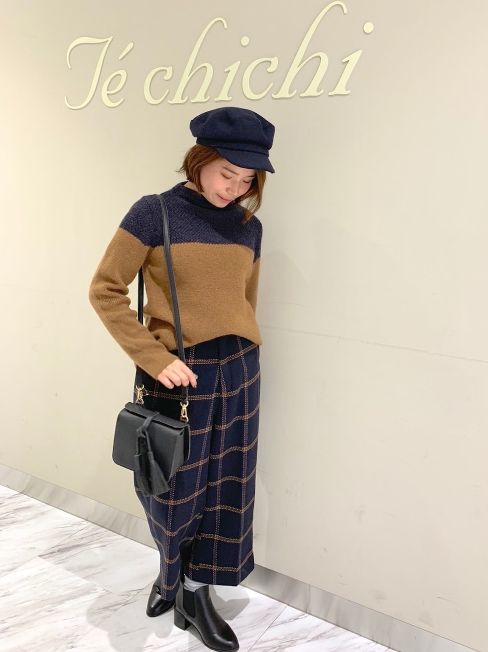 ブラウン系のニット/セーター、ブルー系のその他パンツ、ブラック系のショルダーバッグを着用したレディースの秋コーディネートの1枚目の写真