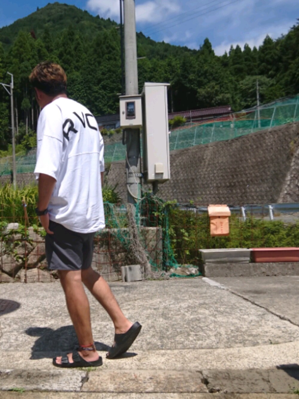 ホワイト系のTシャツ/カットソー、グレー系のその他パンツ、ブラック系のサンダルを着用したメンズの夏コーディネートの1枚目の写真