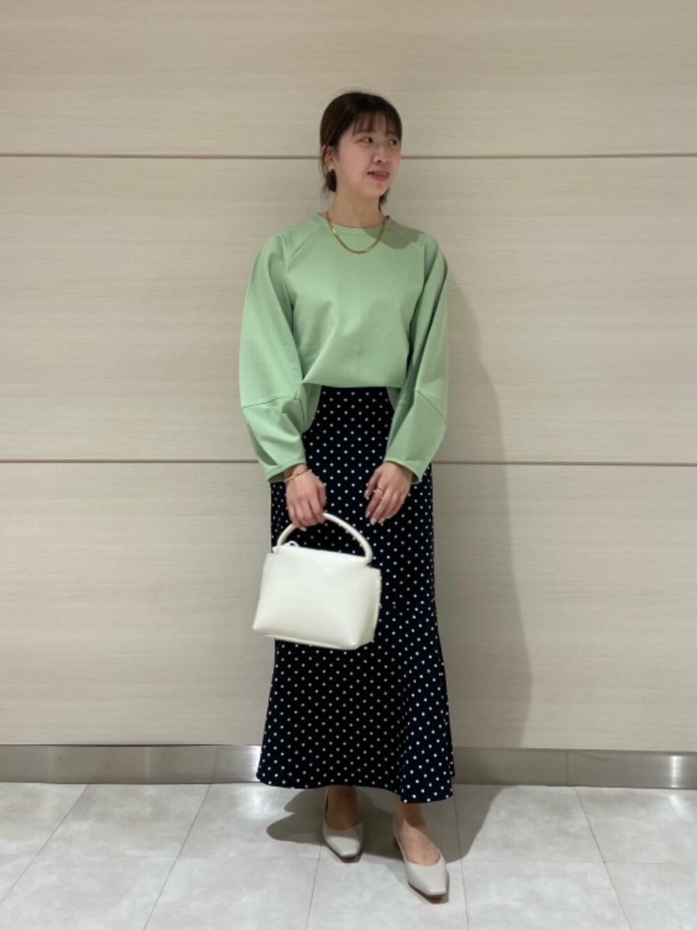 グリーン系のTシャツ/カットソー、その他のスカート、ホワイト系のパンプスを着用したレディースの冬コーディネートの1枚目の写真