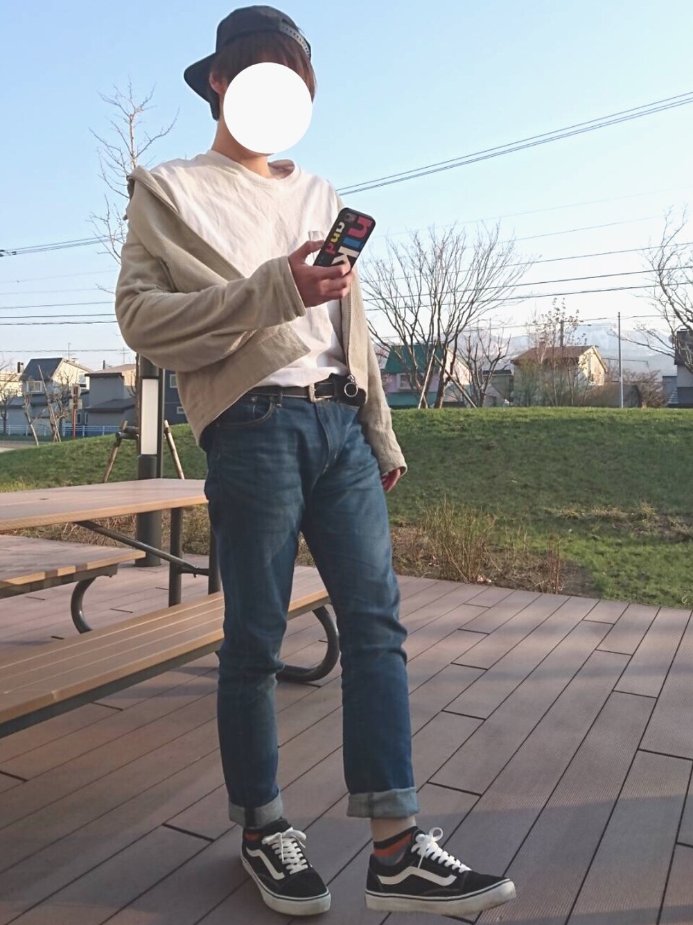 ブルー系のデニムパンツ、ベージュ系のブルゾン、ブラック系のスニーカーを着用したメンズの春コーディネートの1枚目の写真