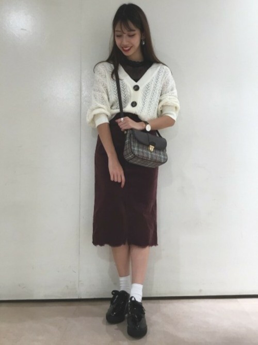 ホワイト系のカーディガン/ボレロ、ブラック系のタンクトップ、パープル系のスカートを着用したレディースの秋コーディネートの1枚目の写真