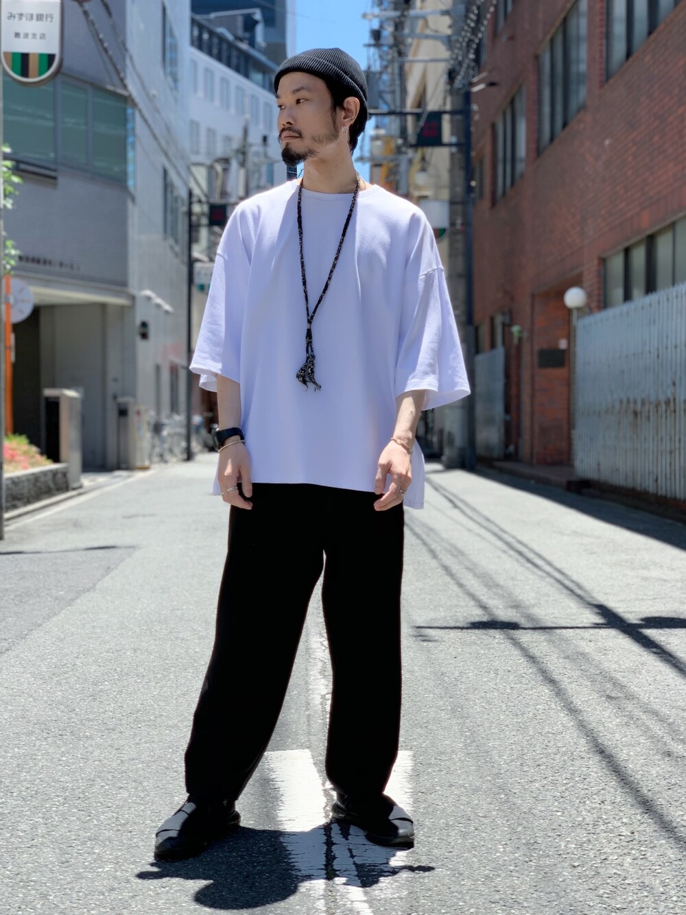 ホワイト系のTシャツ/カットソー、ブラック系のその他パンツ、ブラック系のニットキャップ/ビーニーを着用したメンズの夏コーディネートの1枚目の写真