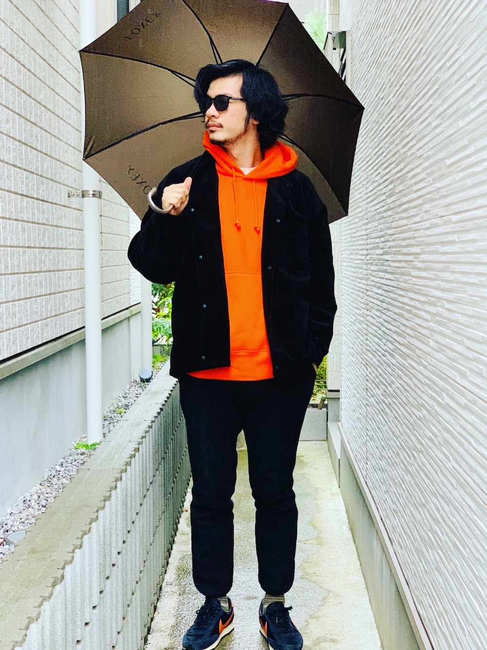 「おしゃれさんと繋がりたい、冬のコーデ、コーデュロイジャケット、オレンジパーカー、ナイキスニーカー、傘、サングラス男子、野生のあっきーな、看護師、シンプルコーデ」｜「無印良品のアイテム（その他アウター、ブラック系）」を使った、野生のあっきーな♂（看護師）さん（メンズ・176cm）の冬コーディネートの1枚目の写真