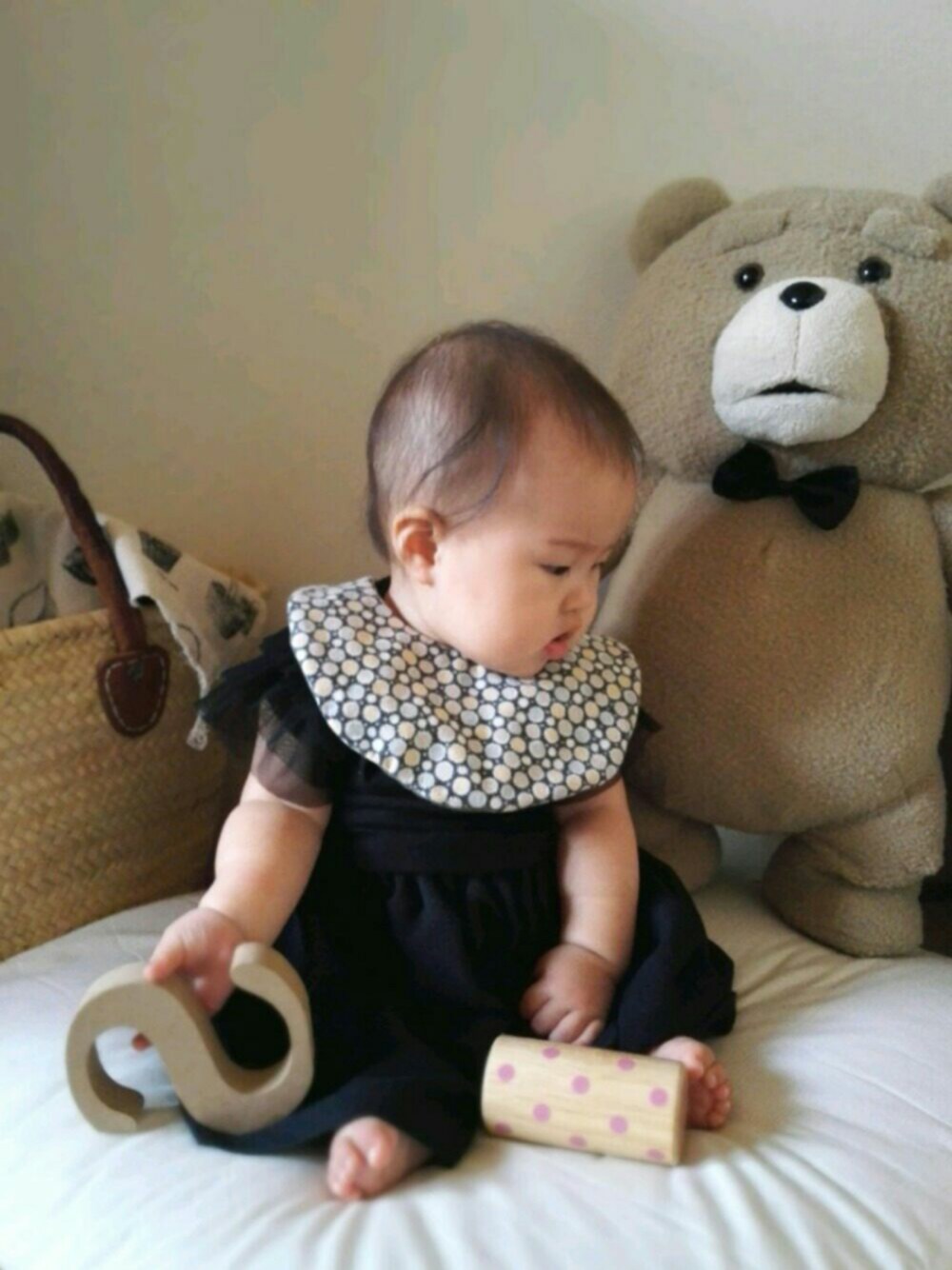 ブラック系のスカート、ブラック系のTシャツ/カットソー、グレー系のスタイ/よだれかけを着用したキッズの秋コーディネートの1枚目の写真