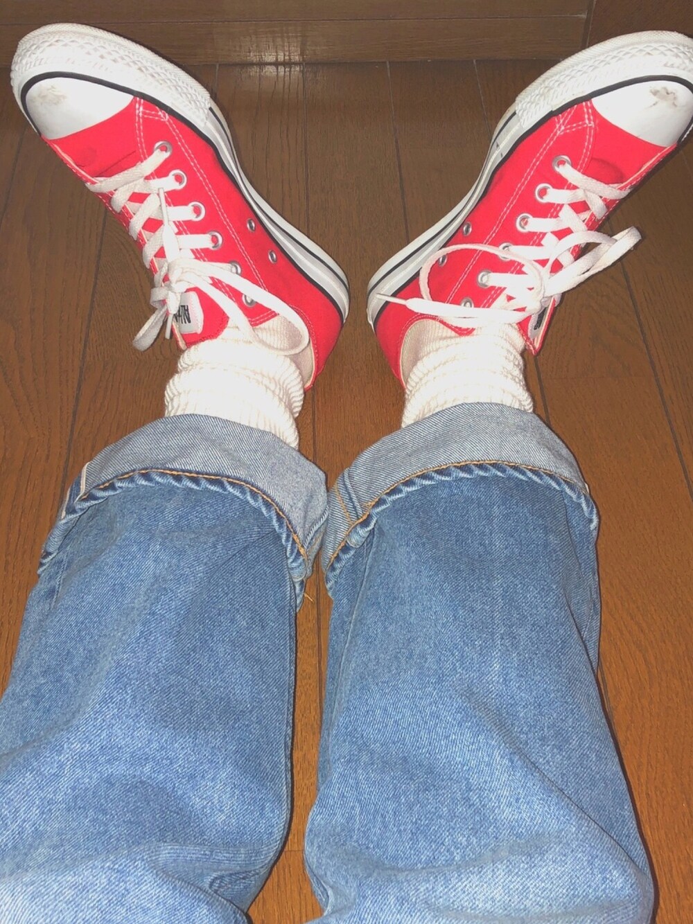 ブルー系のデニムパンツ、レッド系のスニーカー、ホワイト系のソックス/靴下を着用したレディースの春コーディネートの1枚目の写真