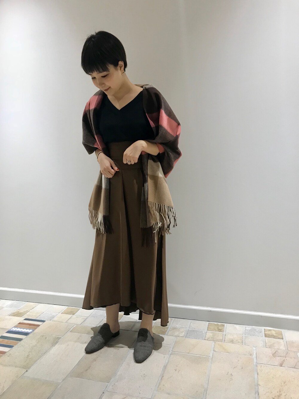 ブラック系のニット/セーター、ブラウン系のスカート、ベージュ系のサンダルを着用したレディースの秋コーディネートの1枚目の写真