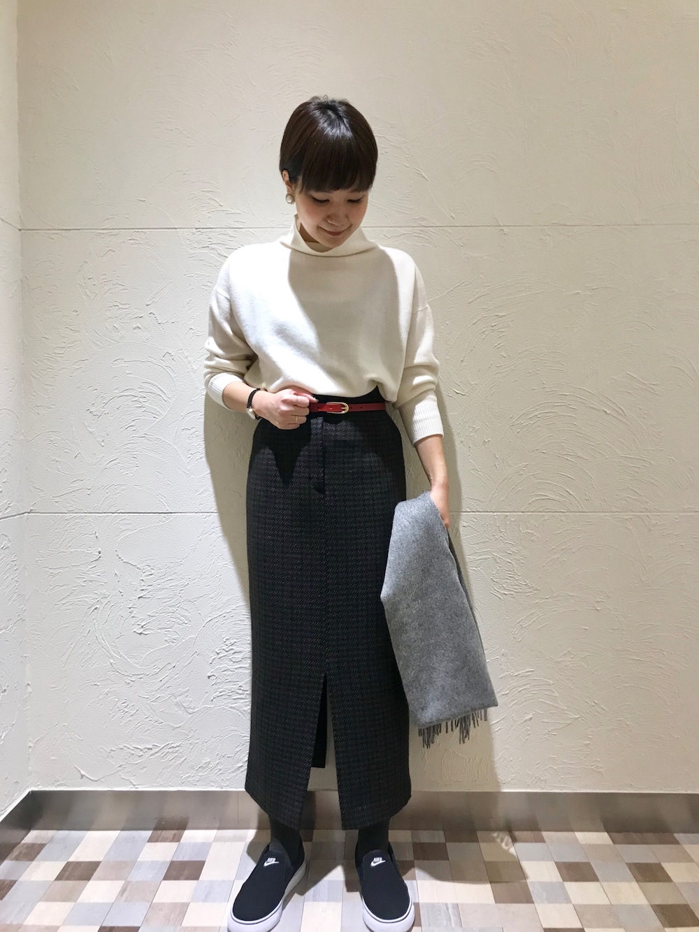 ホワイト系のニット/セーター、ブラウン系のスカート、ブラック系のスリッポンを着用したレディースの秋コーディネートの1枚目の写真