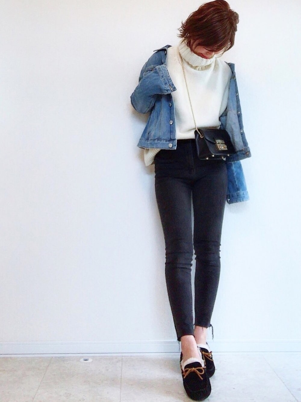 ブルー系のデニムジャケット、ホワイト系のニット/セーター、ブラック系のデニムパンツを着用したレディースの秋コーディネートの1枚目の写真