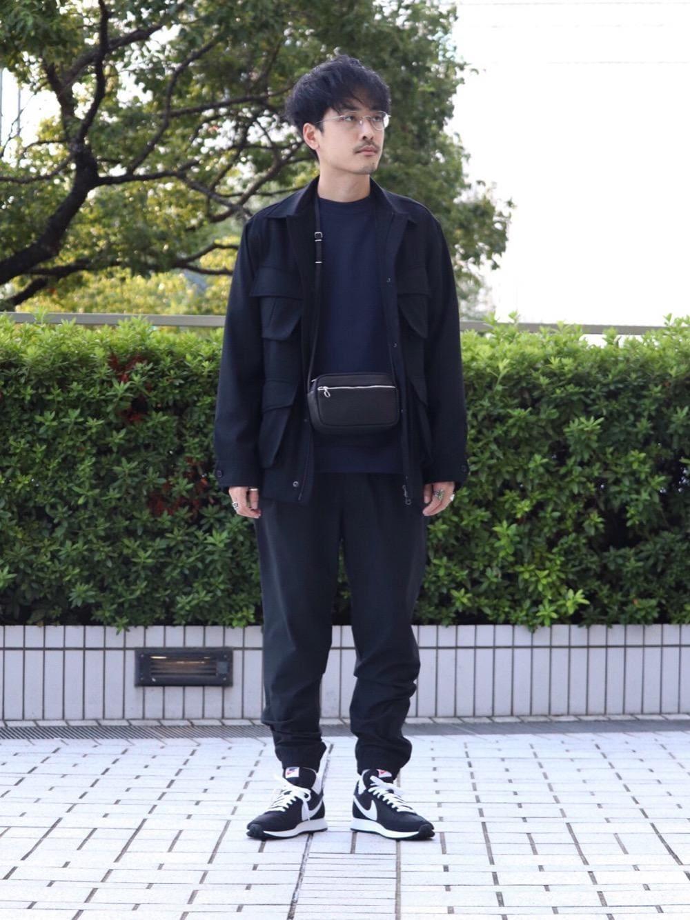 ブラック系のスニーカー、ブルー系のスウェット、ブラック系のその他アウターを着用したメンズの秋コーディネートの1枚目の写真