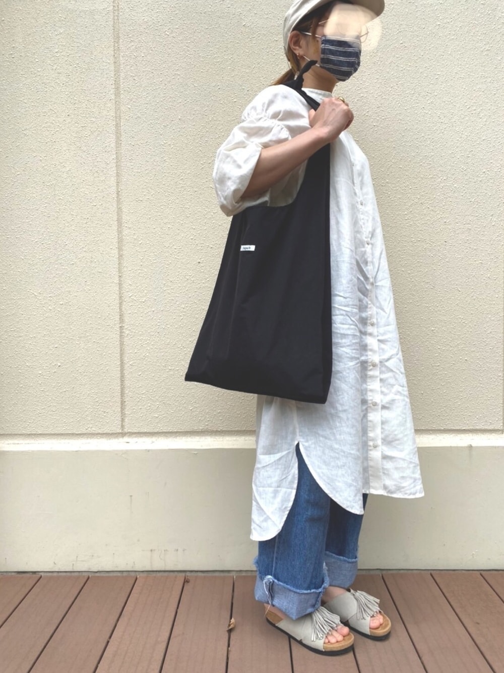 ブラック系のトートバッグ、ホワイト系のワンピース、ブルー系のデニムパンツを着用したレディースの夏コーディネートの1枚目の写真