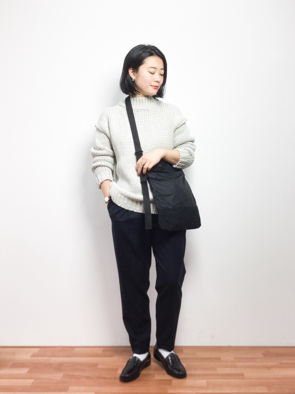 グレー系のニット/セーター、ブルー系のその他パンツ、ブラック系のショルダーバッグを着用したレディースの冬コーディネートの1枚目の写真