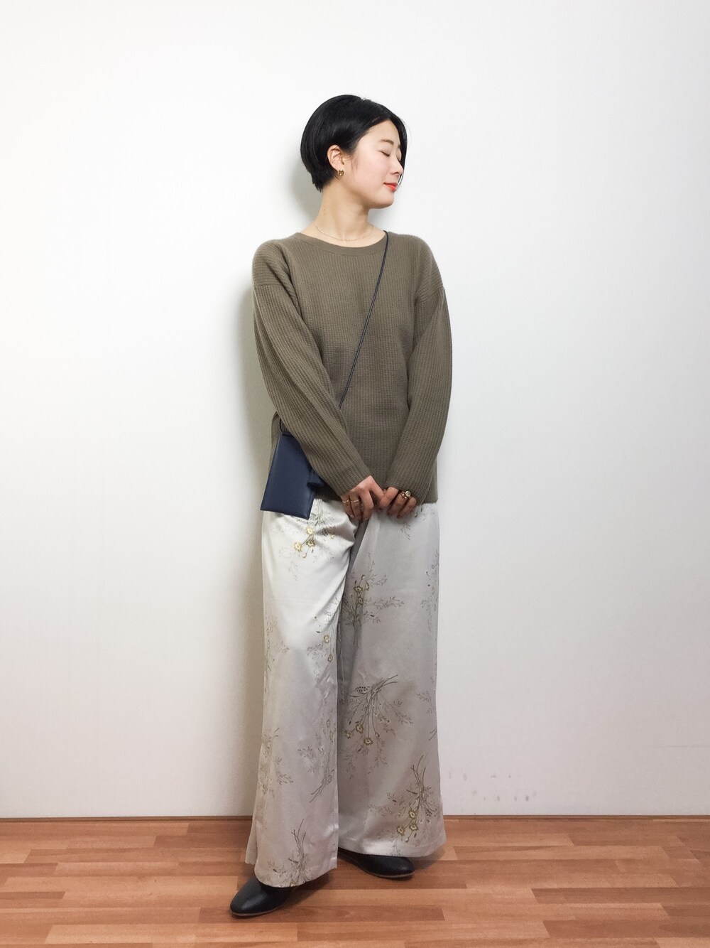 グリーン系のニット/セーター、ベージュ系のその他パンツ、ブラック系のスリッポンを着用したレディースの冬コーディネートの1枚目の写真