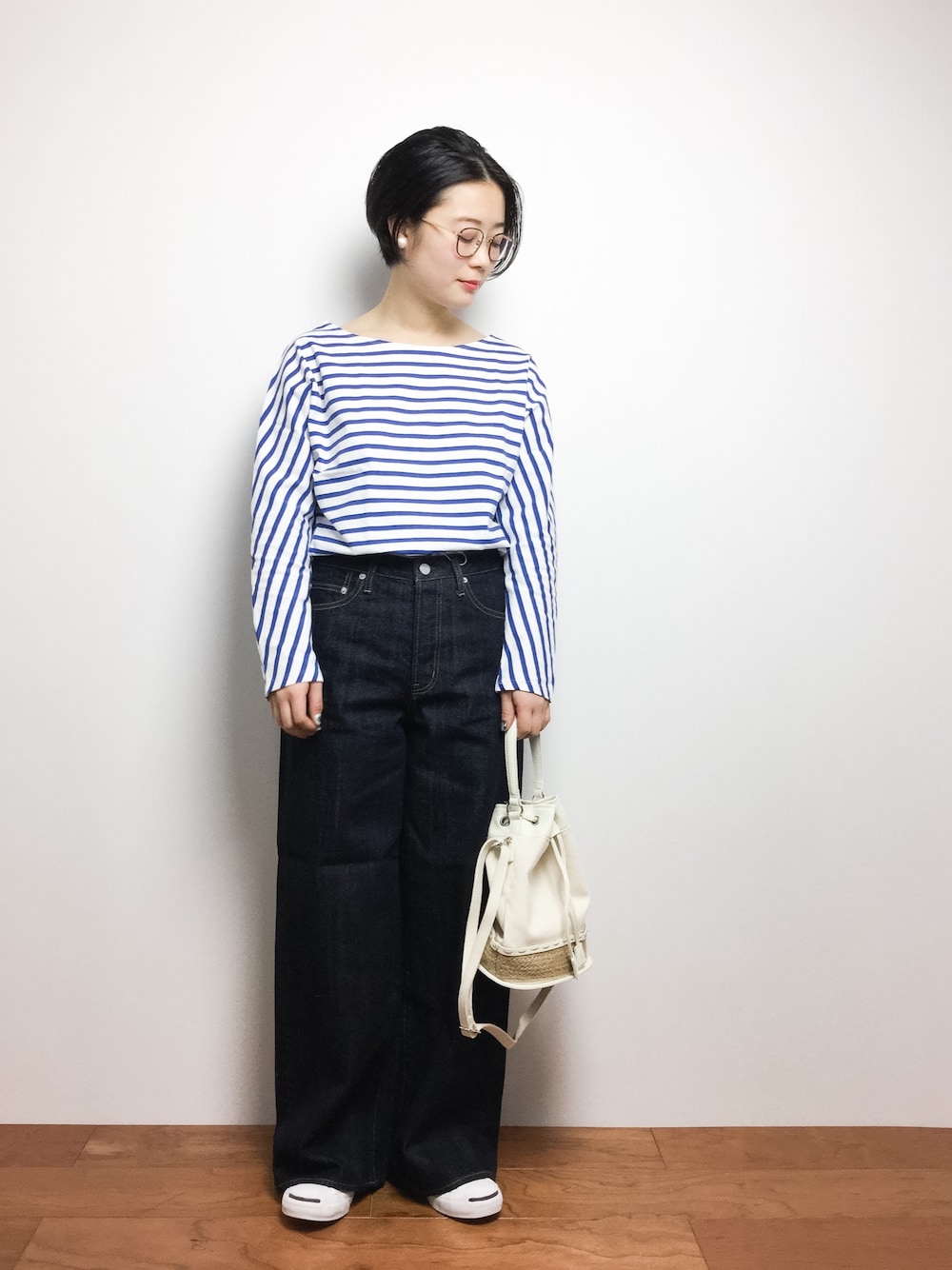 ホワイト系のTシャツ/カットソー、ブルー系のデニムパンツ、ホワイト系のショルダーバッグを着用したレディースの春コーディネートの1枚目の写真