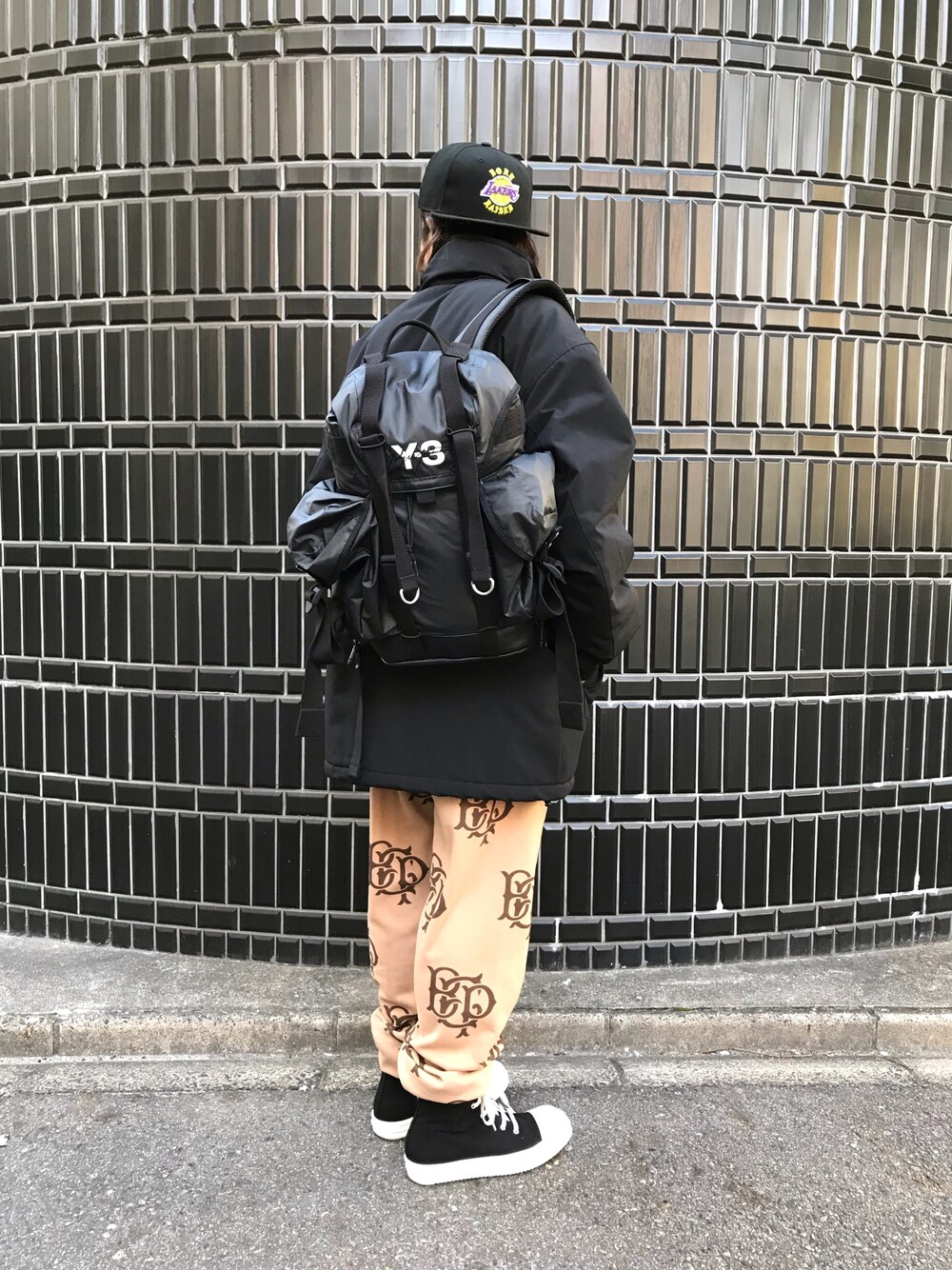 ブラック系のバックパック/リュック、ブラック系のジャケット/アウター、ベージュ系のパンツを着用したメンズの冬コーディネートの1枚目の写真