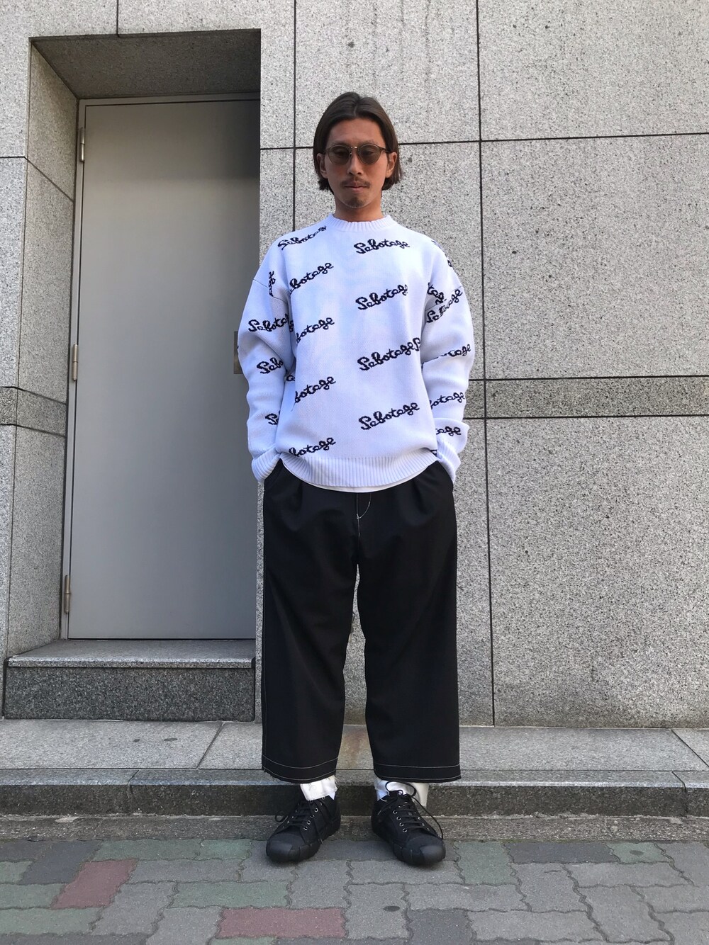 ホワイト系のニット/セーター、ブラック系のパンツ、ブラック系のスニーカーを着用したメンズの冬コーディネートの1枚目の写真