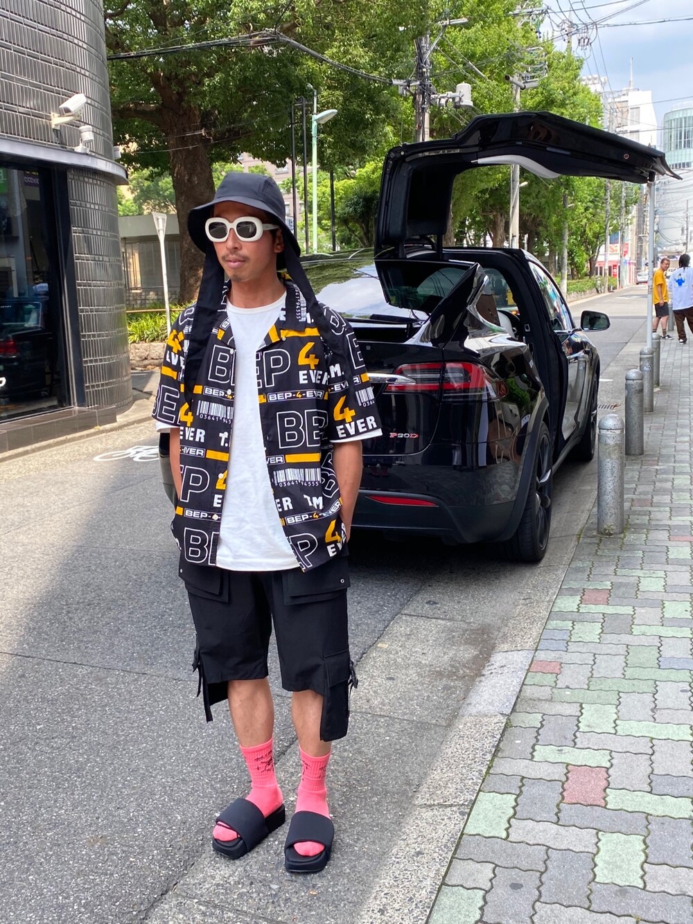 「ショートパンツ、ストリート、サングラス、ビックシルエット、Y-3、バケットハット、ゆるコーデ、blackeyepatch、tesla、modelx」｜「BlackEyePatchのBlackEyePatch/ブラックアイパッチ/4 EVER S/S SHIRT/総柄半袖シャツ（シャツ/ブラウス、ブラック系）」を使った、よしやす(34歳)さん（メンズ・175cm）の夏コーディネートの1枚目の写真