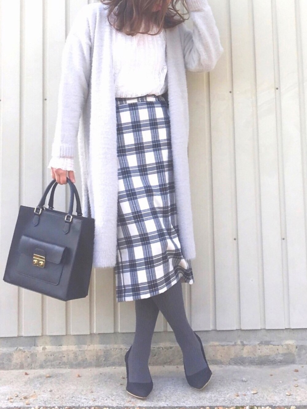 ホワイト系のTシャツ/カットソー、ホワイト系のスカート、ブラック系のショルダーバッグを着用したレディースの冬コーディネートの1枚目の写真