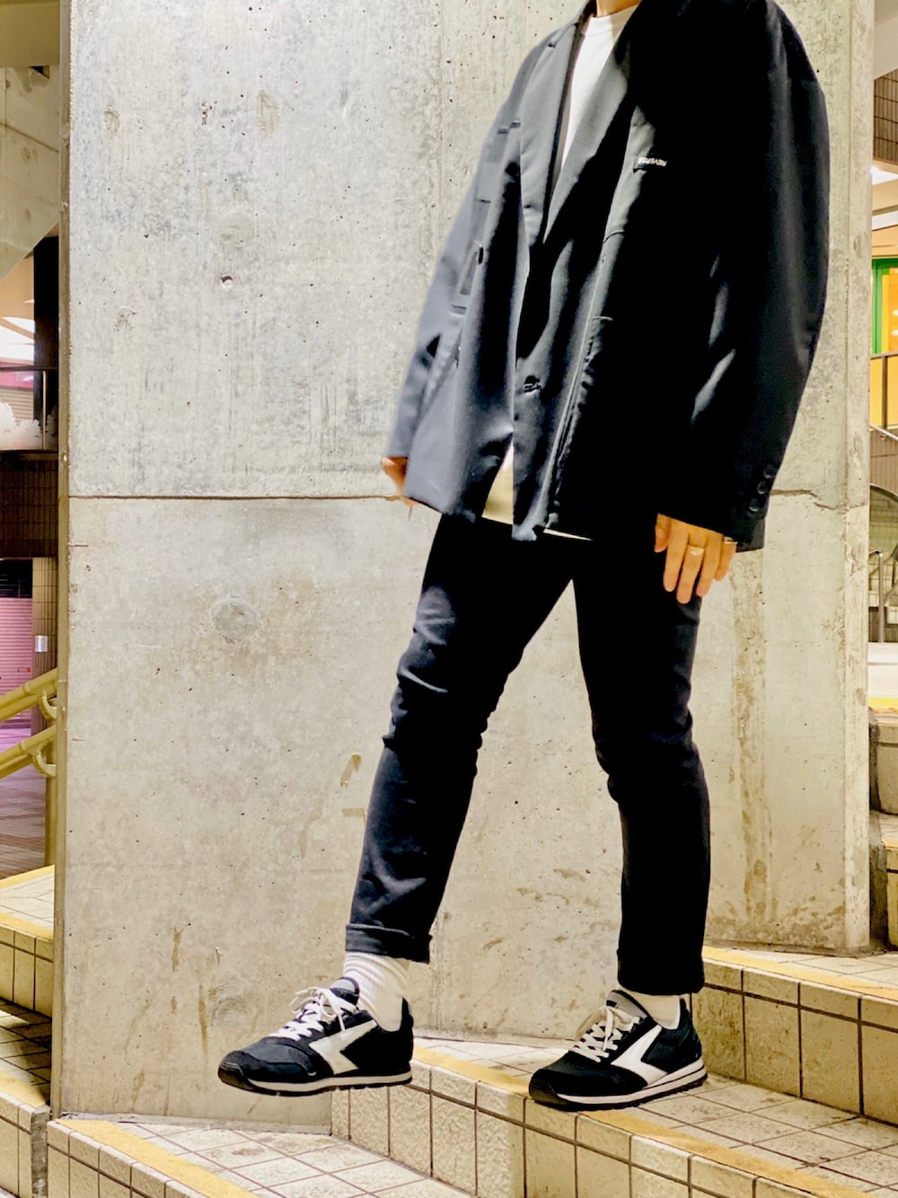 ブラック系のテーラードジャケット、ホワイト系のスウェット、ブラック系のパンツを着用したメンズの春コーディネートの1枚目の写真