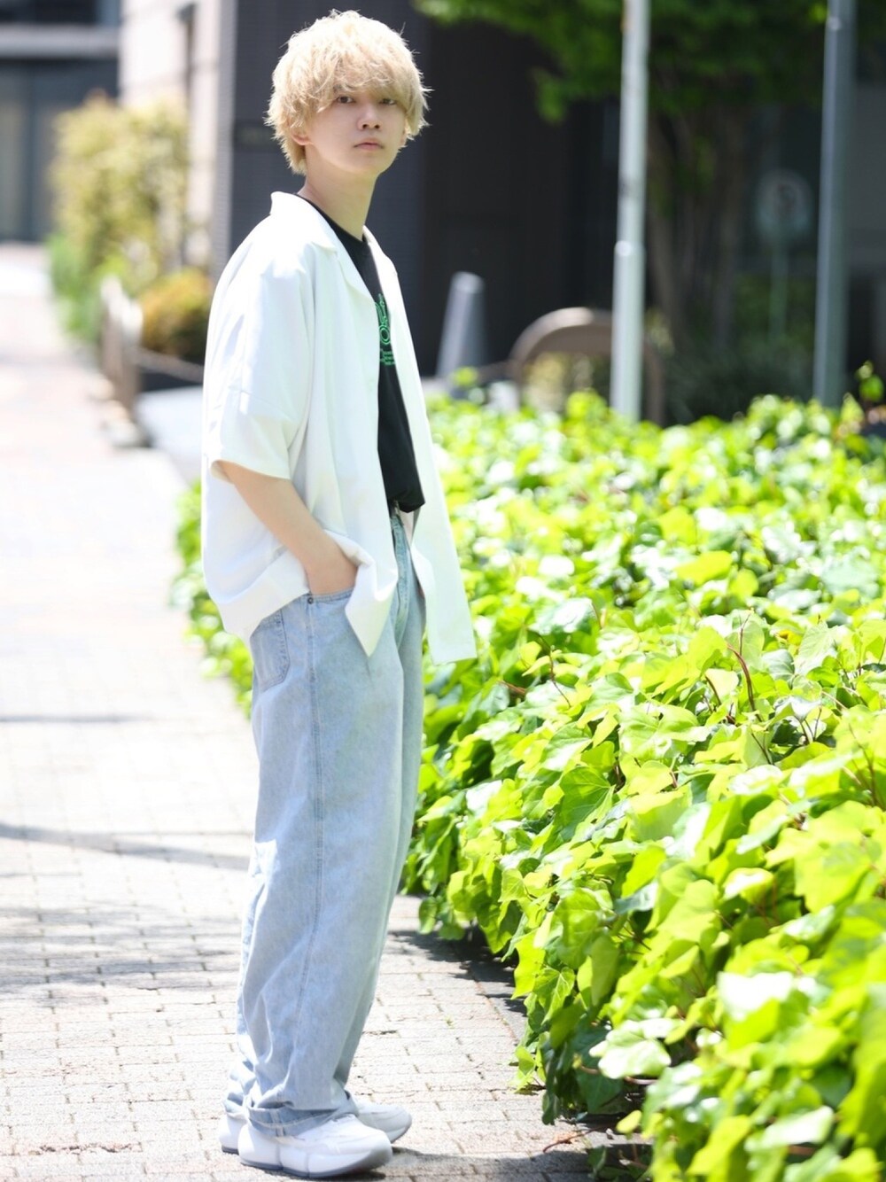 ホワイト系のTシャツ/カットソー、ブルー系のパンツ、ホワイト系のスニーカーを着用したメンズの春コーディネートの1枚目の写真