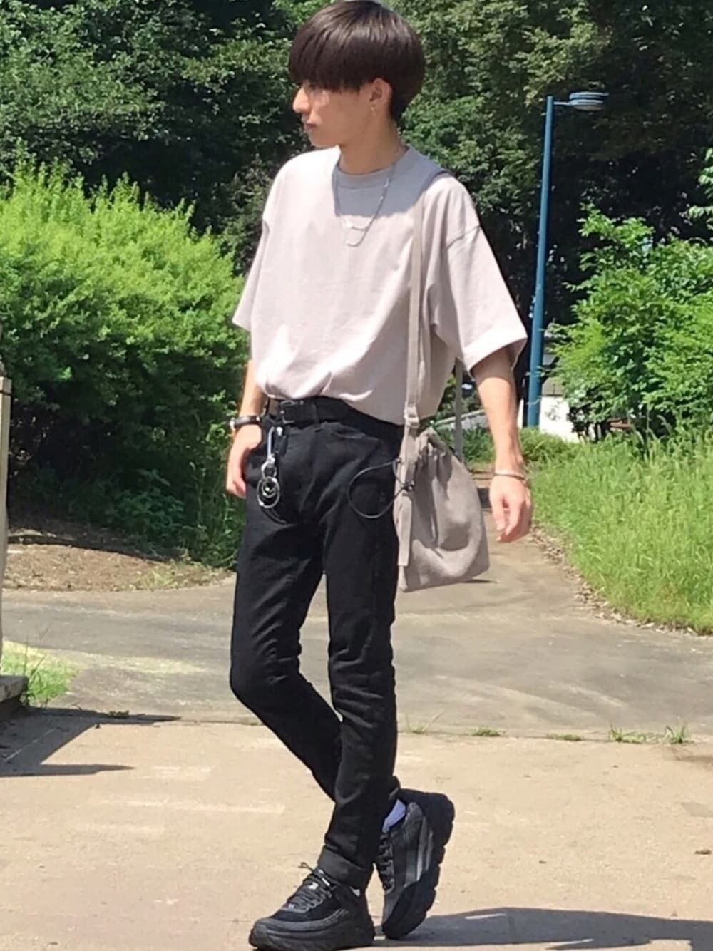 ブラック系のスニーカー、ブラック系のその他パンツ、ベージュ系のTシャツ/カットソーを着用したメンズの夏コーディネートの1枚目の写真