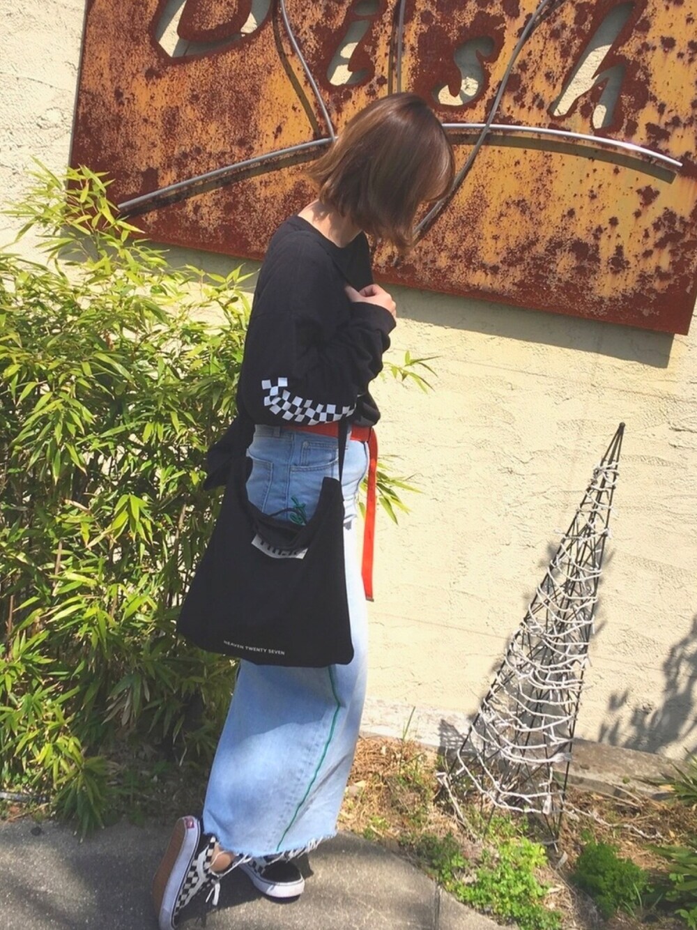 ブラック系のTシャツ/カットソー、ブラック系のトートバッグ、ブルー系のデニムスカートを着用したレディースの春コーディネートの1枚目の写真