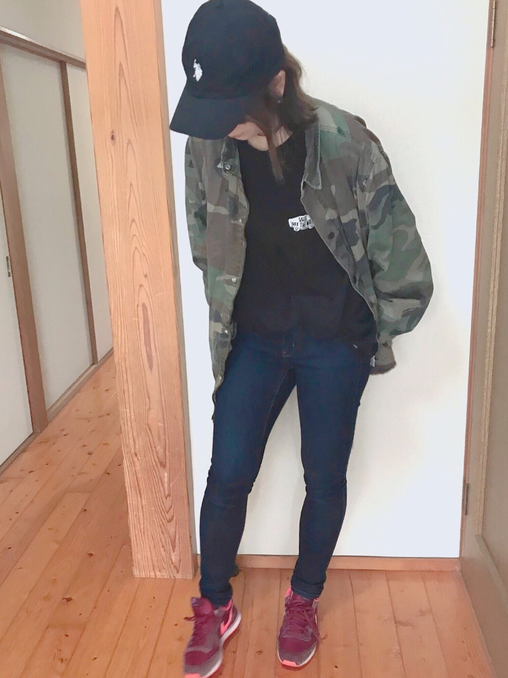 グリーン系のミリタリージャケット、ブルー系のデニムパンツ、レッド系のスニーカーを着用したレディースの春コーディネートの1枚目の写真